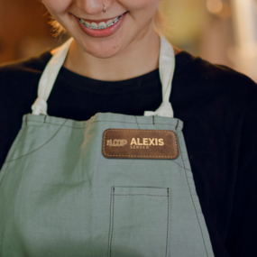 A smiling employee wearing a custom engraved name tag